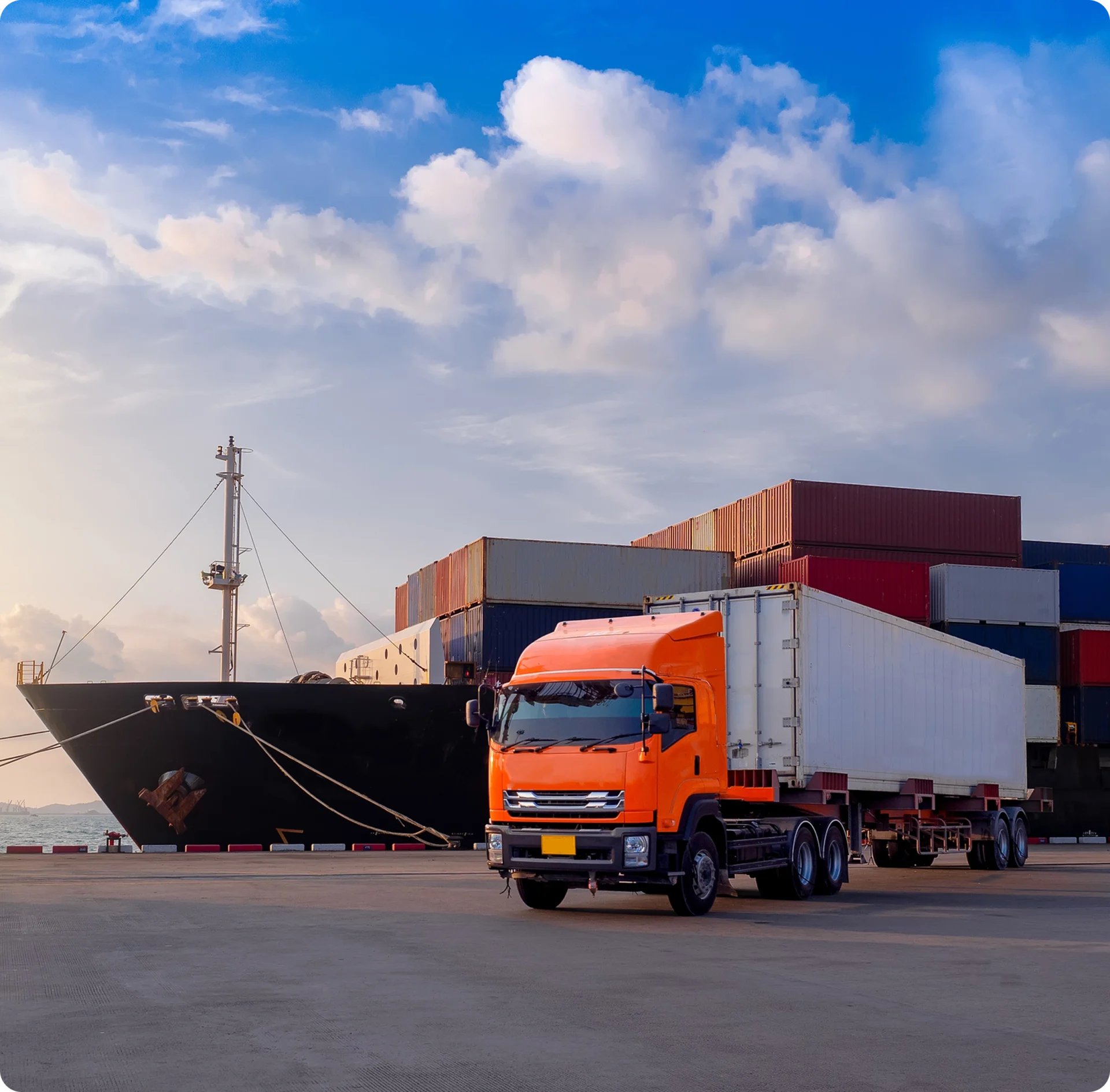 Truck and cargo ship at a port.