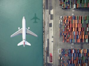 Airplane flying over container port