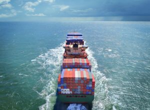 Aerial view of freight ship with cargo containers on the sea.